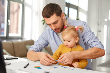 Wall Mural - multi-tasking, freelance and fatherhood concept - working father with baby daughter at home office