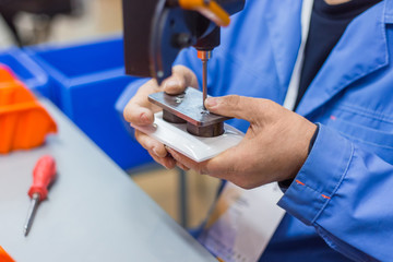 Blind man assembler, electrician hands assembling electric socket at fabric. Repair, production, handmade manufacturing process, electricity and disabled people concept