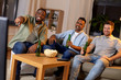 © Syda Productions - friendship, leisure and people concept - happy male friends with beer and popcorn watching tv at home at night