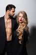 © LIGHTFIELD STUDIOS - handsome man looking at attractive and curly girlfriend with red lips on white