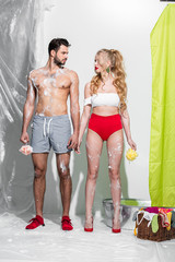 Wall Mural - sexy pin up girl holding wet sponge with soap near shirtless man on white