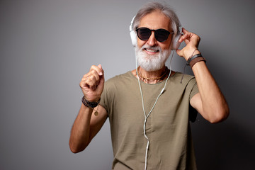 Canvas Print - Enjoying the sound of music. Studio portrait of handsome senior man with gray beard and headphones.