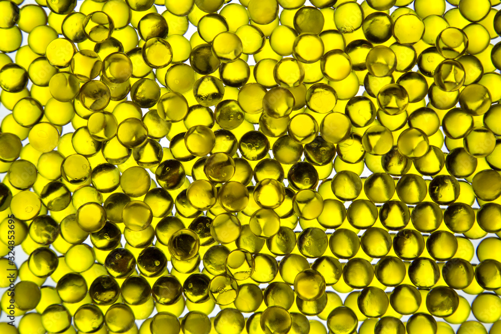 Linseed oil capsules are bright yellow in the contrast light, similar ...