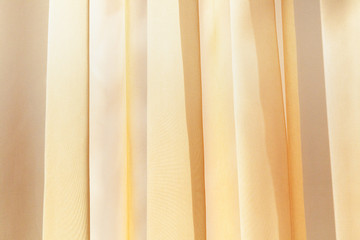 Beige drapery of transparent thin curtains on the window. Organza fabric background.
