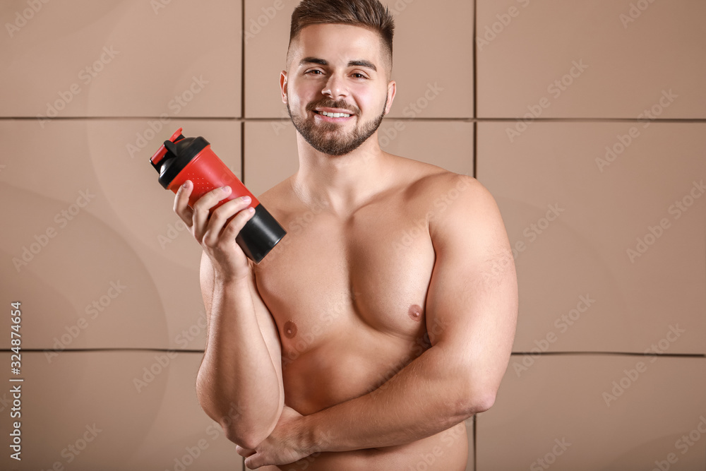Sporty man with protein shake on color background