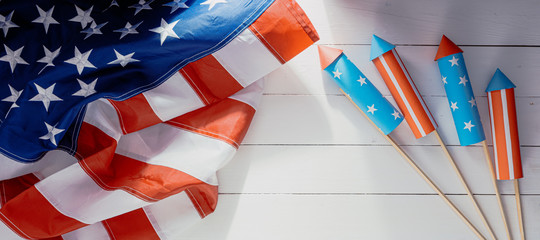 Wall Mural - fireworks and american flag on a white wooden table with place for text. 4th july independence day celebration concept