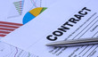 © Zhanna - a sheet of paper with the word contract with a pen lies on the charts