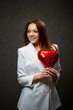 © DSMT - Beautiful girl in a white jacket with a red balloon heart in her hands