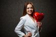 © DSMT - Beautiful girl in a white jacket with a red balloon heart in her hands