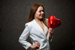 © DSMT - Beautiful girl in a white jacket with a red balloon heart in her hands