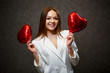 © DSMT - Beautiful girl in a white jacket with a red balloon heart in her hands