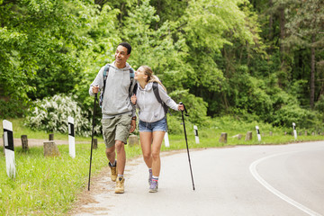 Wall Mural - two friends hiking in nature.they walking by the old country road.