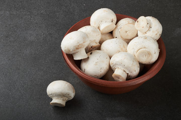 Fresh champignon mushrooms on wooden table, closeup. Space for text