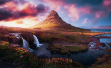 Awesome Nature Landscape. Colorful Clouds Under Sunlight Appear Over Mount Kirkjufell During Sunset In Iceland. Popular Tourist Attraction. Best Famous Travel Locations. Scenic Image Of Iceland