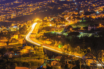 Wall Mural - Aerial view of highway at night crossing the famous Funchal capital in Madeira island