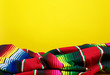 Colorful Mexican serape blanket on a yellow background