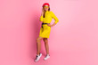 © ClaudiK - Young smiling woman in acid yellow mini dress is looking to camera at the pink copy space. Full length studio shot.Full length portrait of a beautiful smiling woman in dress. Not isolated