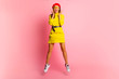 © ClaudiK - Active Person. Happy young red hair girl in yellow dress and glasses dancing jumping over pink studio wall, full length attractive happy smiling stylish woman at studio. Horizontal, not isolated