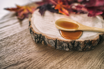 Wall Mural - Maple syrup sugar liquid in wooden spoon from Quebec restaurant sugar shack called Cabane a sucre maple trees sap farm. Canadian delicacy sweet dessert ingredient,