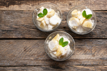 Wall Mural - Banana with sour cream on wooden background