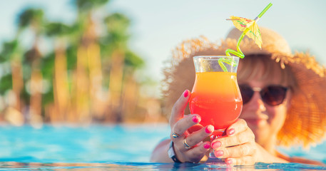 Wall Mural - cocktail in the hands of a woman. Selective focus.