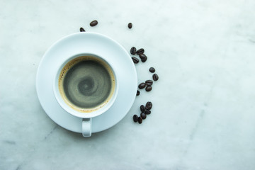 Wall Mural - Top View, Closed up hot coffee mug on white plate and cup with heap of coffee's beans on grey granite background.