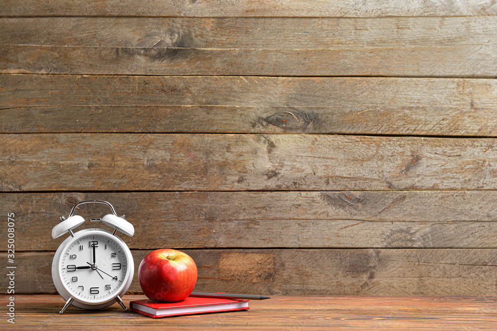 School supplies, apple and clock on table. Time to study