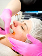 Professional female cosmetologist doing hydrafacial procedure in Cosmetology clinic. Doctor use hydra vacuum cleaner. Rejuvenation And Hydratation. Cosmetology. Profile