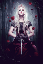 Queen In The Forest. A Girl In A Fairy Tale Image Of A Dark Queen With Bright Makeup And A Crown In The Forest