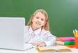 © Ermolaev Alexandr - Smiling young gurl uses laptop in a school