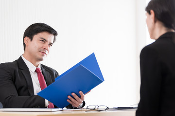 A businessman listens and talking to candidate woman answers for a job interview.