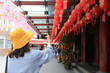 © Monthira - Asian woman using smart phone to take a photo of chinese new year lanterns in the china town in singapore