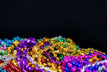 Strings Of Colorful Festival Beads With A Black Background.  Selective Focus.  Blurred Foreground.  Blurred Background.