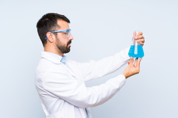 Wall Mural - Young scientific holding laboratory flask over isolated background