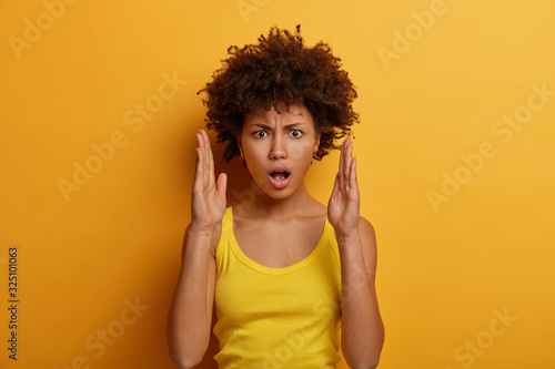 Fotomural Indignant shocked woman makes big size with hands, tells about something huge, h