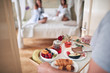 © luckybusiness - young man bringing breakfast in bed for two female. lesbian, bisexual, threesome concept