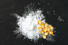 Corn Starch With Yellow Grains On A Black Background, Top View. Corn White Starch And Yellow Kernels On The Table. Starch And Corn Grains On A Black Background, Top View.