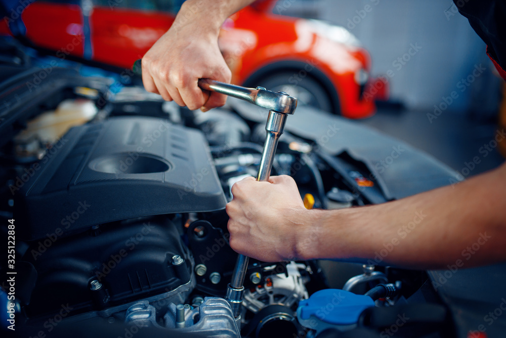 Worker disassembles vehicle engine, car service