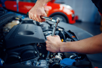 Wall Mural - Worker disassembles vehicle engine, car service