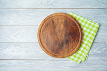 Round Pizza Board With Green Checked Tablecloth On Rustic Wooden Table .Kitchen, Cooking Or Baking Mock Up Background For Design.