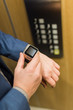 Close up of businessman looking at blank screen smart watch in elevator. Business and office building meeting concept.
