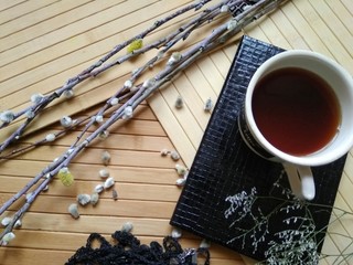 cup of coffee and black notebook on wooden background