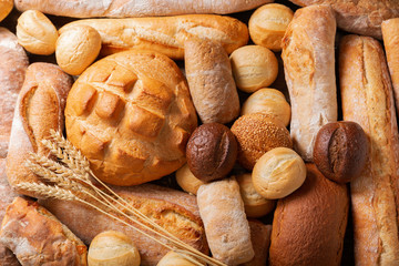 Fresh baked bread and wheat ears, top view