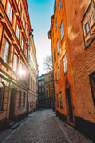 Fototapeta Uliczki - Beautiful cozy narrow street in Gamla Stan - old town of Stockholm. Historic european facades of buildings