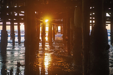 under the pier at sunset