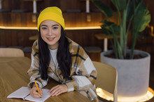 Happy Attractive Asian Woman With Beautiful Face Writing Notes, Working Startup Project. University Student Studying, Learning Language, Exam Preparation In Library. Portrait Of Stylish Korean Hipster