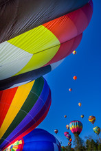 Many Colorful Hot Air Balloons On The Ground And Lifting Off Into Clear Blue Sky
