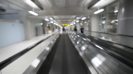 Canvas Print - Out of focusing/blurred inside the airport while on flatted escalator while moving with passenger walking on it. Technology Transportation concept. Inside airport departure terminal building.