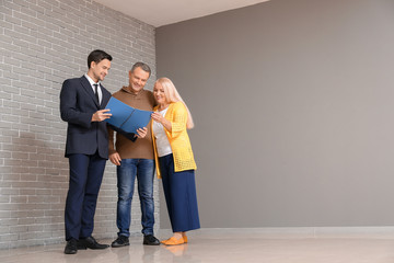 Poster - Male real estate agent working with mature couple indoors