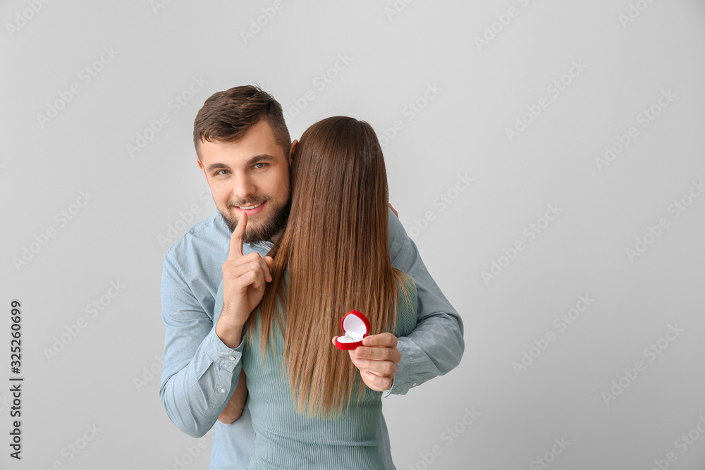 Young man going to make proposal to his beloved on light background